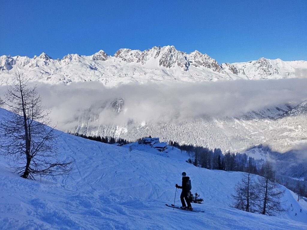 Skier off-piste with cloud and mountains in the distance