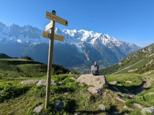 A hiker sitting on a rock looking at MontBlanc