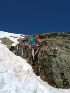 Hiker on ladder above snow