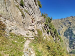 Hiker on path crossing cliff face