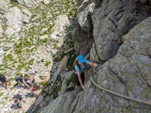 Hiker ascending rungs on a steep section