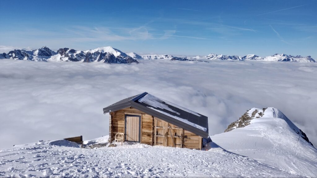 Wooden hut on snowy ridge at the Col des Rachasses