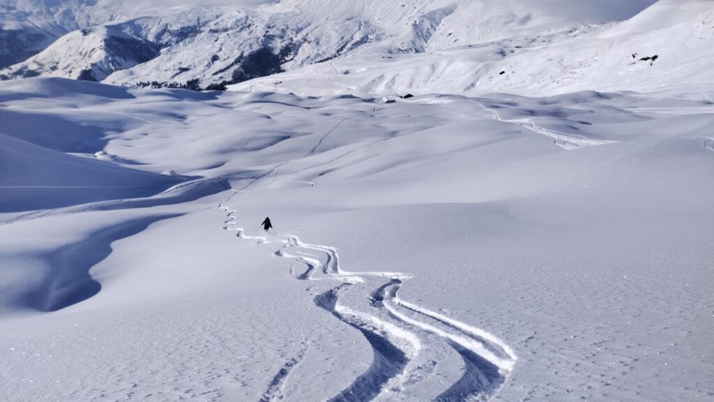 Skier descending untracked snow below the Col de la Fenêtre