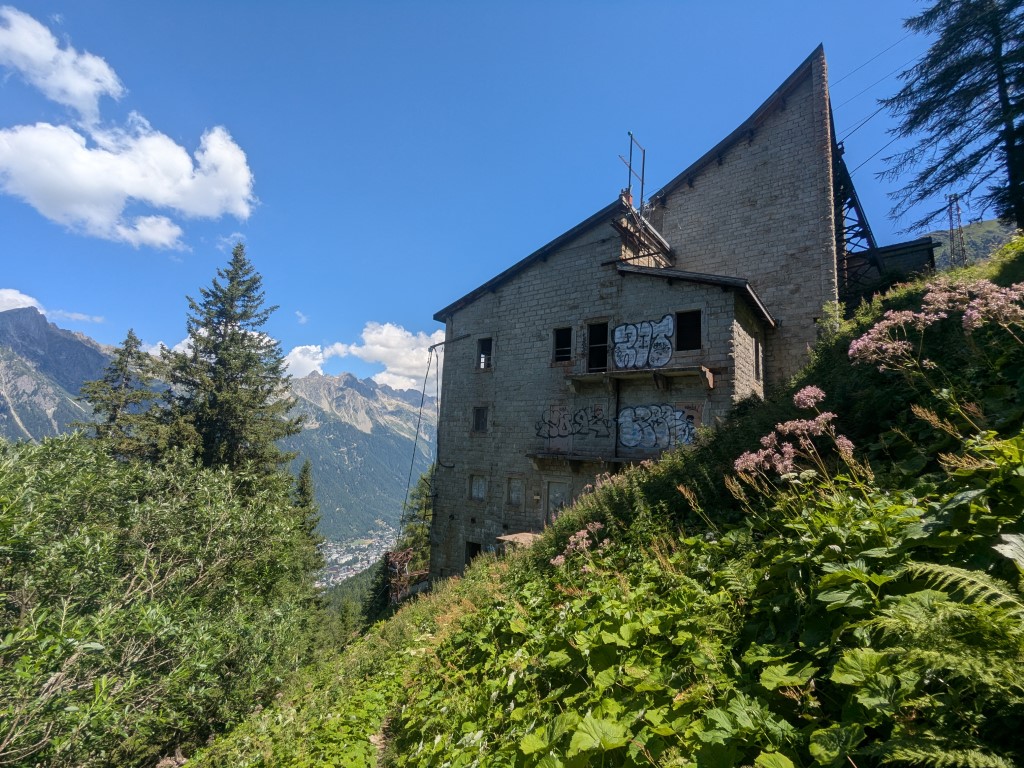 Gare de la Para cable car station - a large abandoned granite building on a forested mountainside